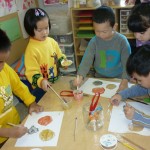 Children using gold, silver, and bronze paing to create medals